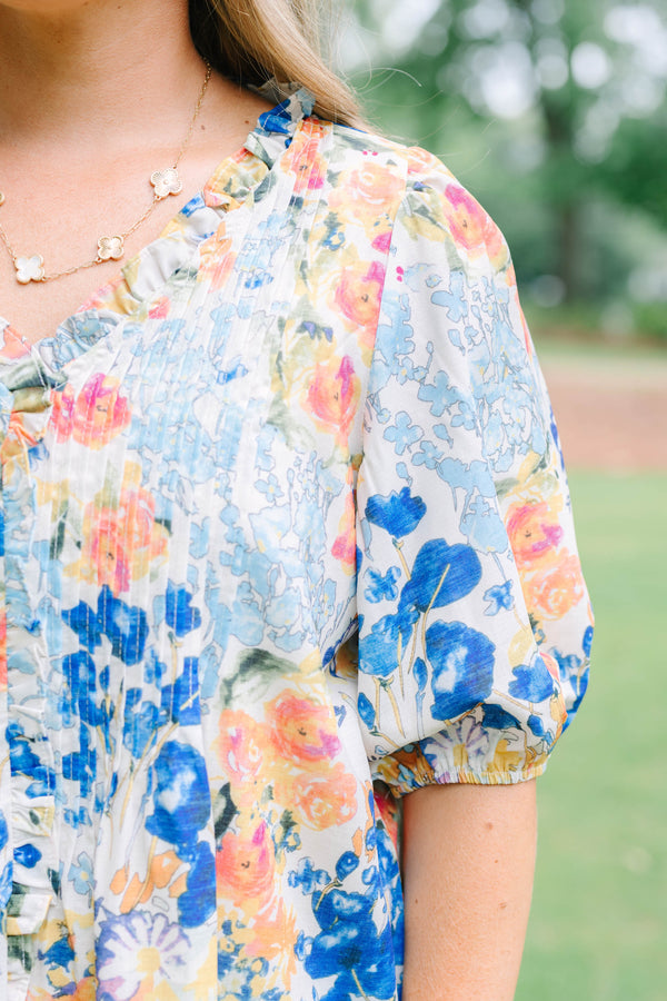Plus Size floral print top in blue, orange, and yellow with pleated front and puff sleeves.