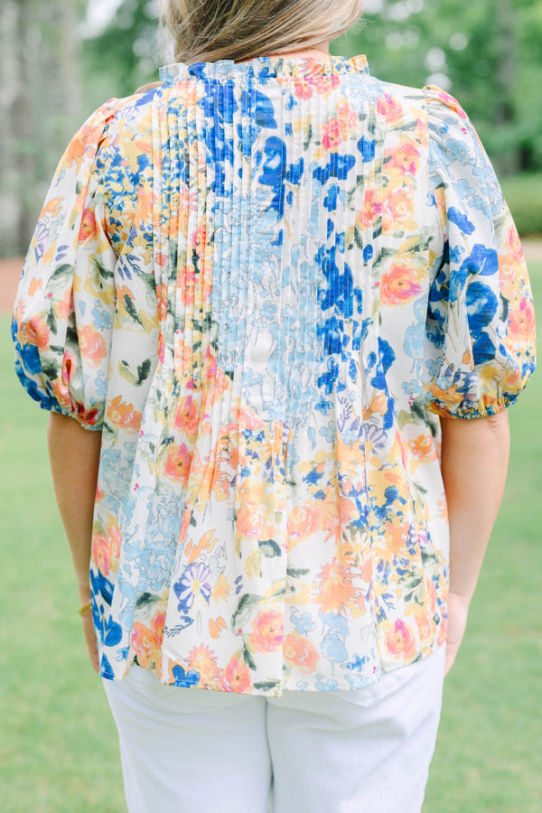 Plus Size floral print top in blue, orange, and yellow with pleated front and puff sleeves.