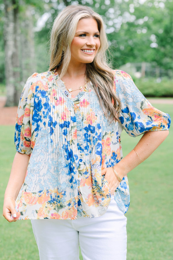 Plus Size floral print top in blue, orange, and yellow with pleated front and puff sleeves.