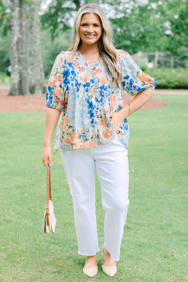 Plus Size floral print top in blue, orange, and yellow with pleated front and puff sleeves.