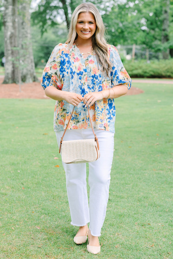 Plus Size floral print top in blue, orange, and yellow with pleated front and puff sleeves.