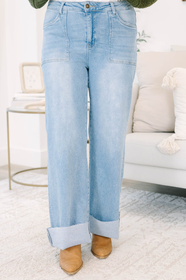 Plus size light wash high-rise wide-leg jeans featuring oversized cuffed hems and patch pockets.