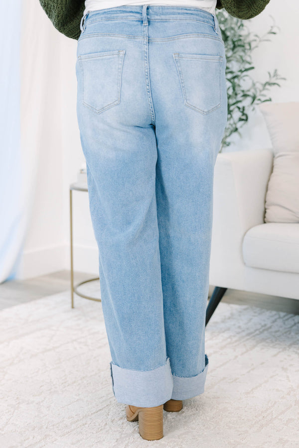 Plus size light wash high-rise wide-leg jeans featuring oversized cuffed hems and patch pockets.