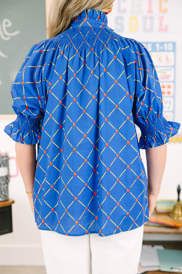 Plus Size navy top with a yellow pencil and red apple grid pattern, smocked neck, and puff sleeves.