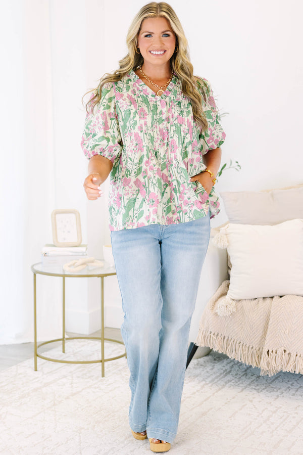Plus size pink and green floral print top with puff sleeves and a flowy, pleated silhouette.