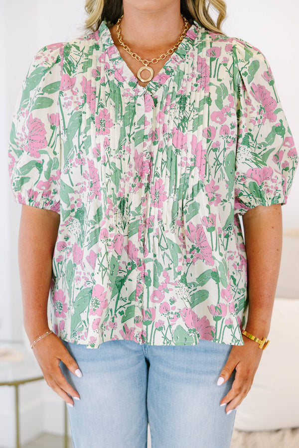 Plus size pink and green floral print top with puff sleeves and a flowy, pleated silhouette.