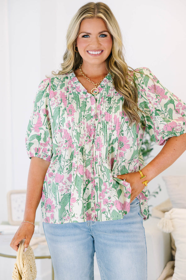 Plus size pink and green floral print top with puff sleeves and a flowy, pleated silhouette.