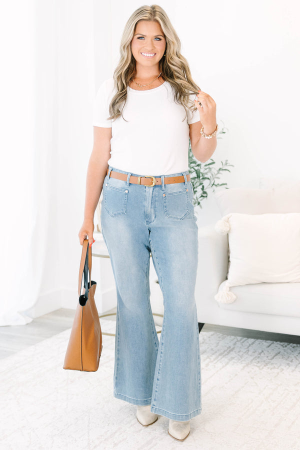 Plus Size medium wash flare jeans with front patch pockets and a high-waisted fit.