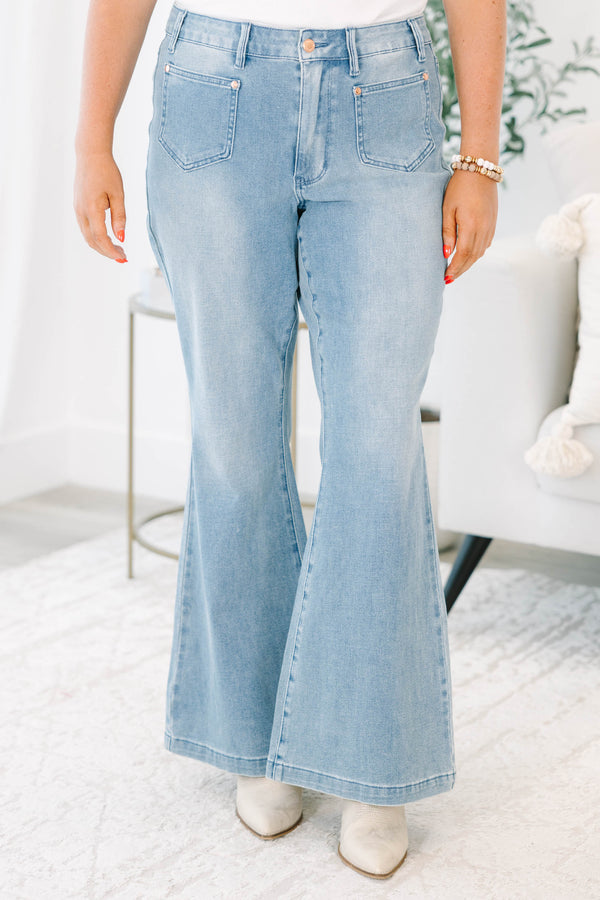 Plus Size medium wash flare jeans with front patch pockets and a high-waisted fit.