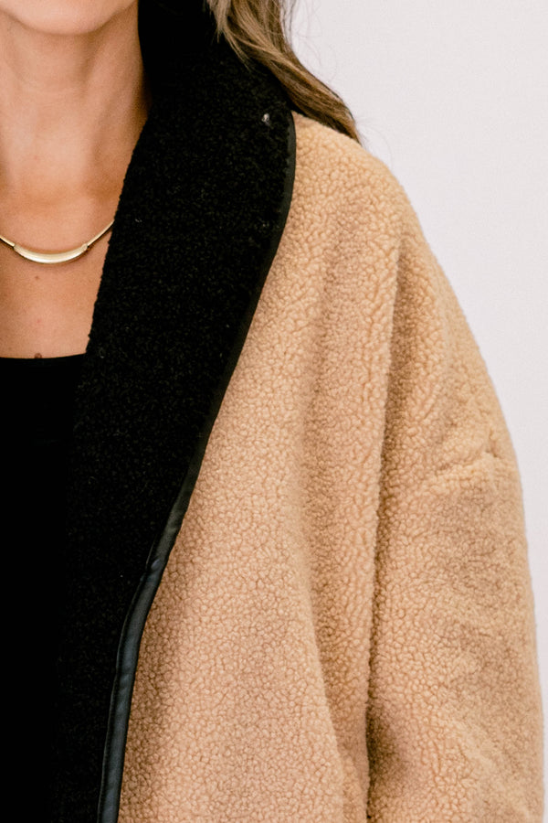 Chic Soul plus size clothing, camel fur colored jacket that has black details going around the ends of each sleeve and on the bottom of the jacket as well as button details going down the left side of the jacket 