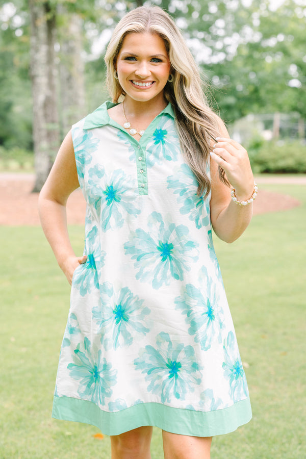 Plus Size sleeveless white dress with green floral print, a collared neckline, and button placket.