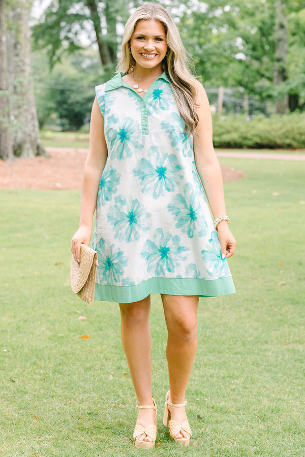 Plus Size sleeveless white dress with green floral print, a collared neckline, and button placket.
