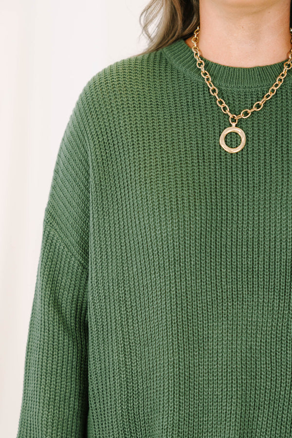 Plus size olive green oversized knit sweater with a relaxed fit and crew neckline.