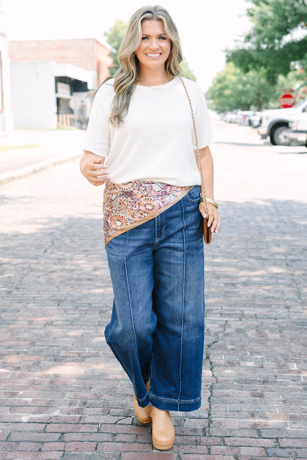 Plus Size high-rise, wide-leg dark wash jeans with front pintuck seams and a wide hem.