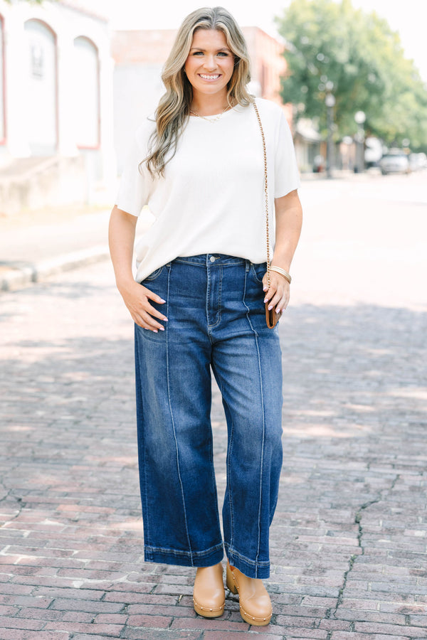 Plus Size high-rise, wide-leg dark wash jeans with front pintuck seams and a wide hem.