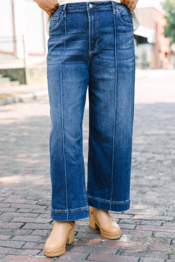 Plus Size high-rise, wide-leg dark wash jeans with front pintuck seams and a wide hem.