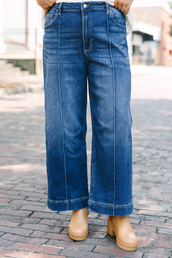 Plus Size high-rise, wide-leg dark wash jeans with front pintuck seams and a wide hem.
