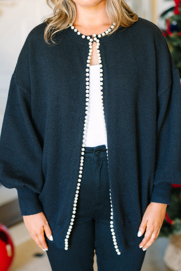 Plus size black cardigan with pearl trim along the neckline and open front, worn over a white top.