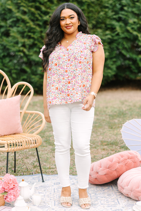 Chic Soul plus size clothing, pink top with a multi-color floral pattern throughout and fluttersleeeves with a slight v-neckline and ruffle details going along the collar of the top 
