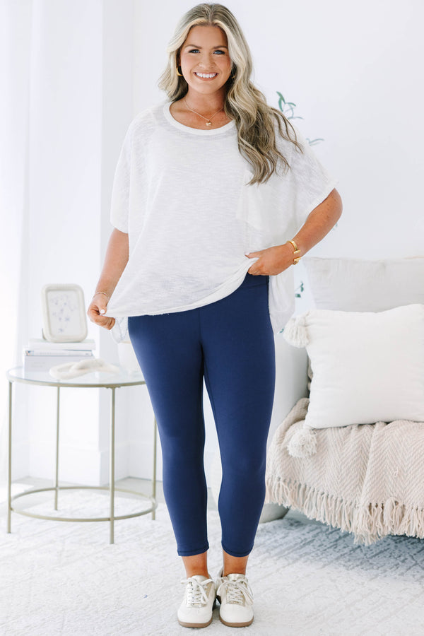 Plus size navy blue high-waisted leggings with a cropped fit and stretchy fabric.