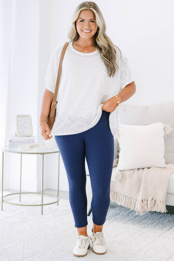 Plus size navy blue high-waisted leggings with a cropped fit and stretchy fabric.