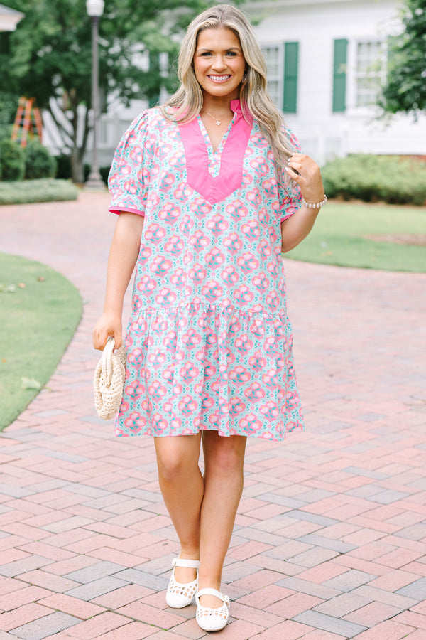 Plus Size pink and green floral print dress with a V-neckline, pink trim, and short puff sleeves.