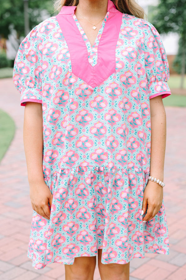 Plus Size pink and green floral print dress with a V-neckline, pink trim, and short puff sleeves.