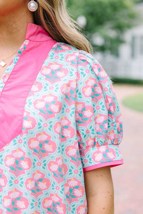 Plus Size pink and green floral print dress with a V-neckline, pink trim, and short puff sleeves.