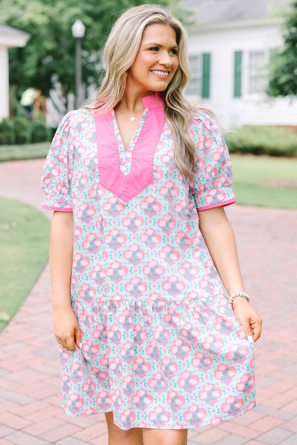 Plus Size pink and green floral print dress with a V-neckline, pink trim, and short puff sleeves.