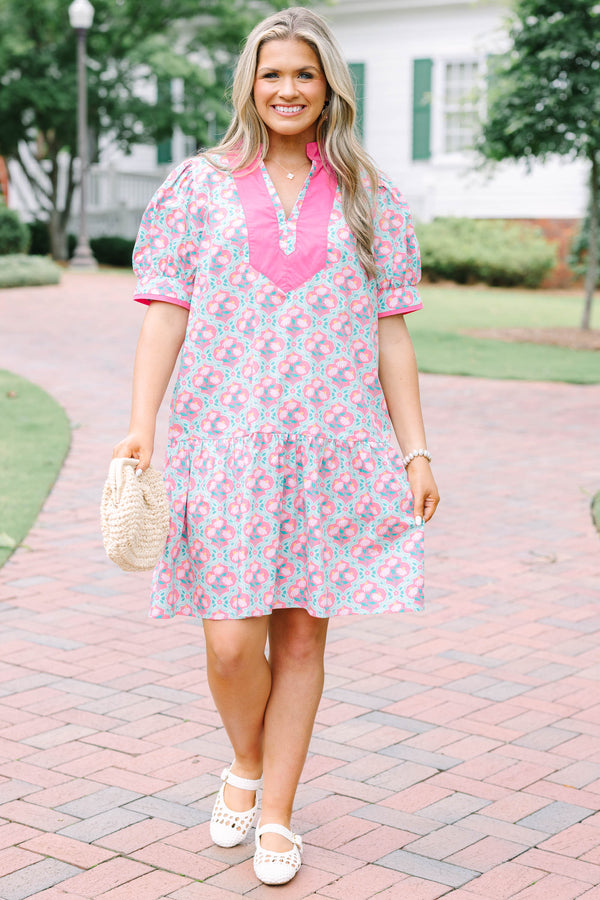 Plus Size pink and green floral print dress with a V-neckline, pink trim, and short puff sleeves.