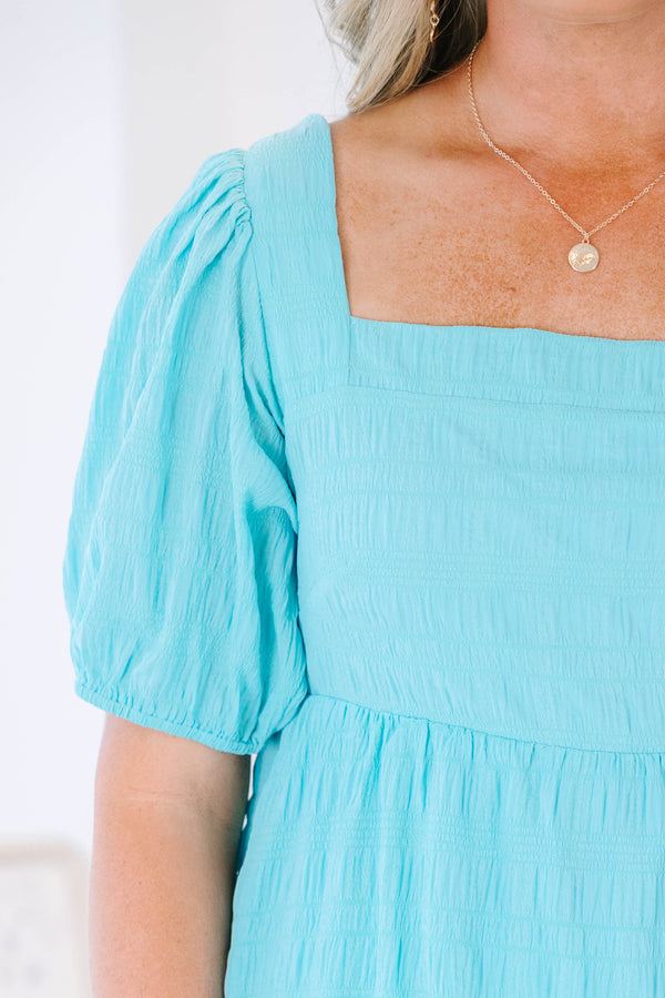 Plus Size lake blue babydoll top with a square neckline, smocked texture, and bubble sleeves.