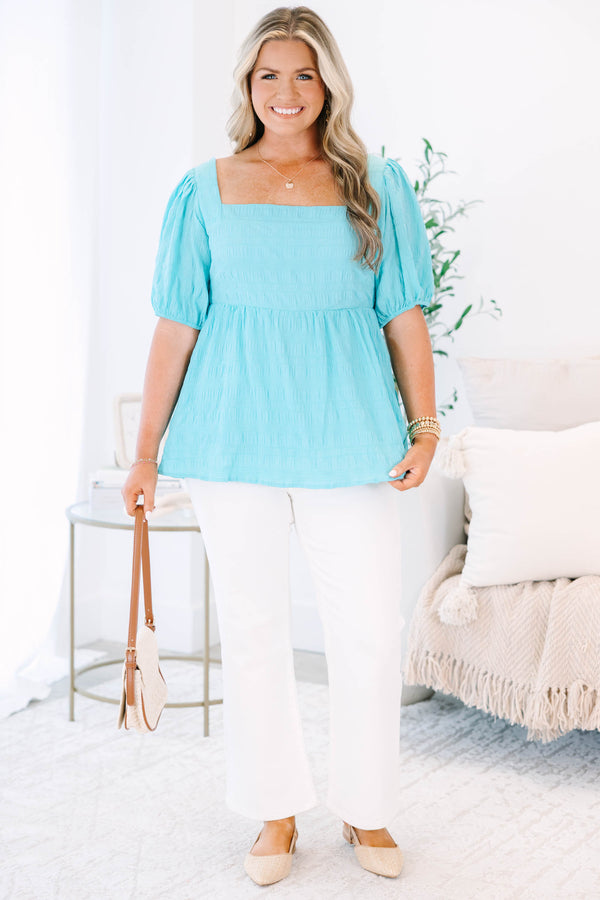 Plus Size lake blue babydoll top with a square neckline, smocked texture, and bubble sleeves.