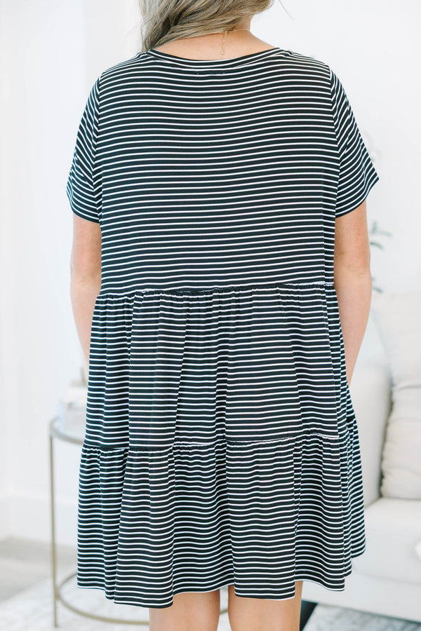 Plus size black and white striped babydoll dress with a flowy tiered skirt and short sleeves.