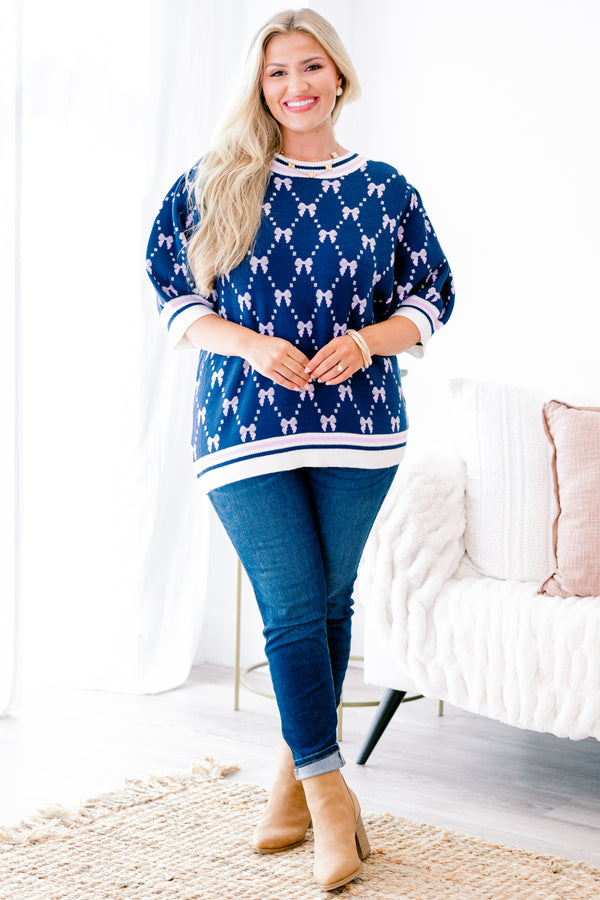 Chic Soul Plus size Clothing, Navy blue short sleeve sweater with a bow print throughout and a white cuff with a stripe on the ends of each sleeve and bottom of the shirt 
