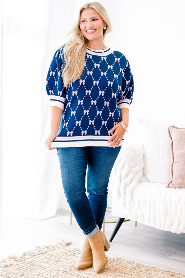Chic Soul Plus size Clothing, Navy blue short sleeve sweater with a bow print throughout and a white cuff with a stripe on the ends of each sleeve and bottom of the shirt 
