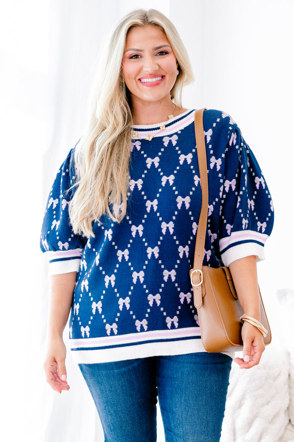 Chic Soul Plus size Clothing, Navy blue short sleeve sweater with a bow print throughout and a white cuff with a stripe on the ends of each sleeve and bottom of the shirt 
