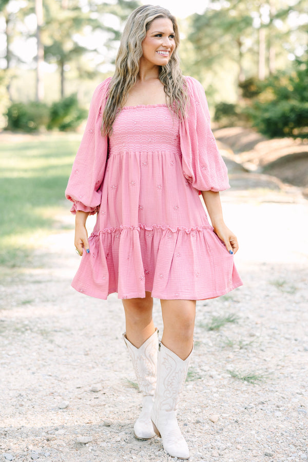 Plus size pink cotton dress with smocked bodice, long puff sleeves, and floral embroidery.