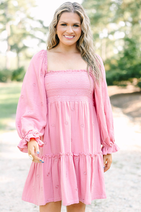 Plus size pink cotton dress with smocked bodice, long puff sleeves, and floral embroidery.
