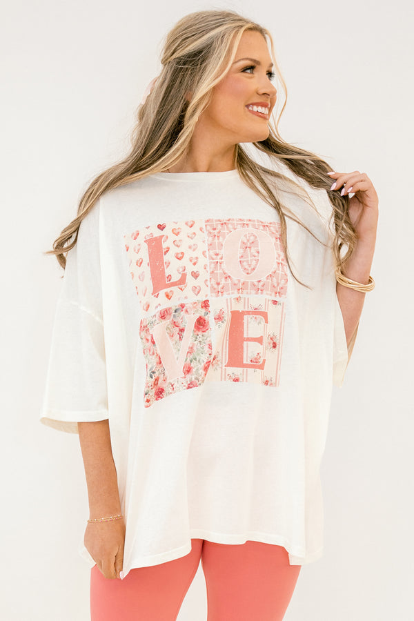 Woman wearing a white t-shirt with floral 'LOVE' design on a plain background