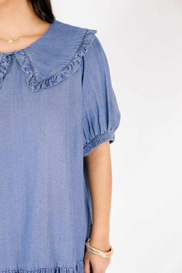 Chic Soul plus size clothing, Denim knee length dress with bubble sleeves and a bib collar that has ruffle detailing going along the edge of the bib as well as a ruffle detail on the bottom tier of the dress 
