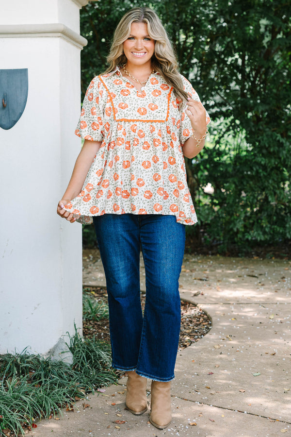 Plus Size floral babydoll top in burnt orange and green with a square yoke and short puff sleeves.