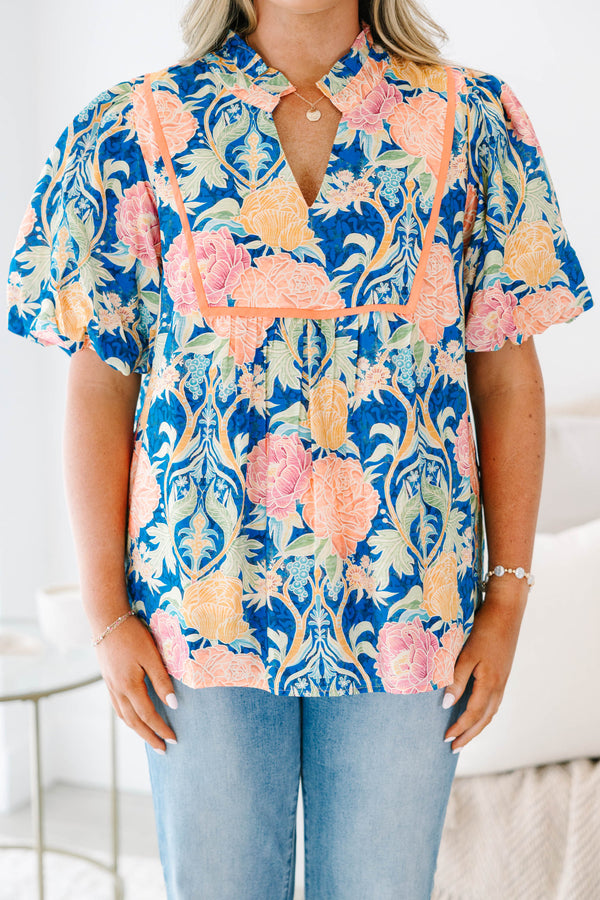 Plus Size blue floral babydoll top with puff sleeves, a notched neckline, and orange trim.