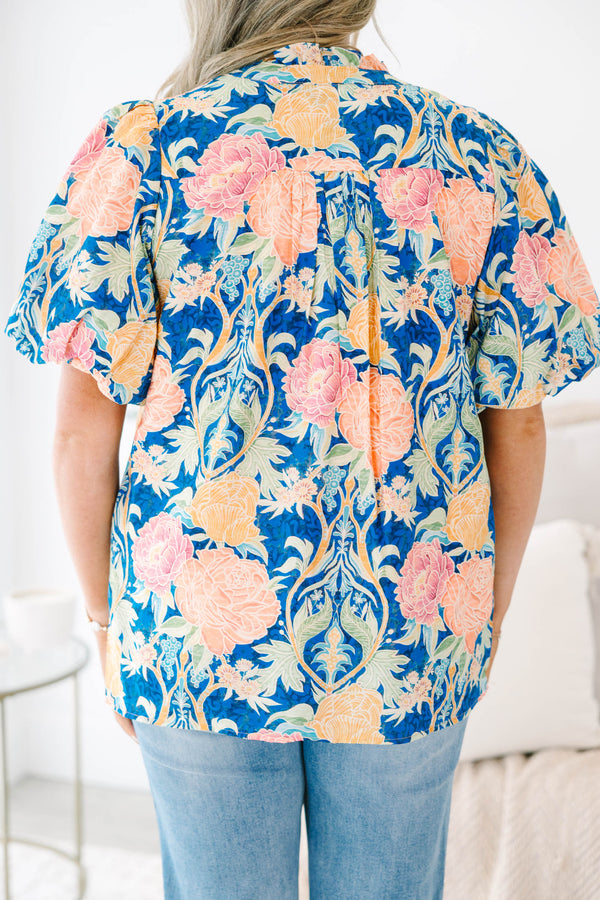 Plus Size blue floral babydoll top with puff sleeves, a notched neckline, and orange trim.
