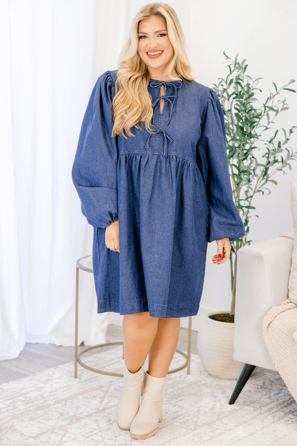 Chic Soul plus size clothing, dark wash denim long puff sleeve knee length baby doll dress with v neck cutout and strings tying in 3 bows down the collar
