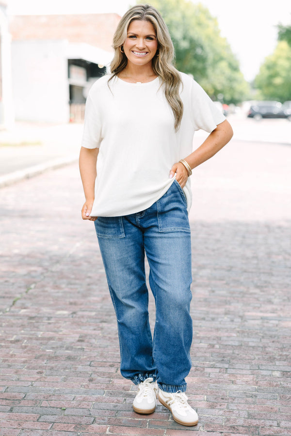 Plus Size medium wash high-rise cargo jogger jeans with front patch pockets and elasticized cuffs.