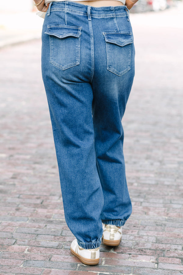 Plus Size medium wash high-rise cargo jogger jeans with front patch pockets and elasticized cuffs.