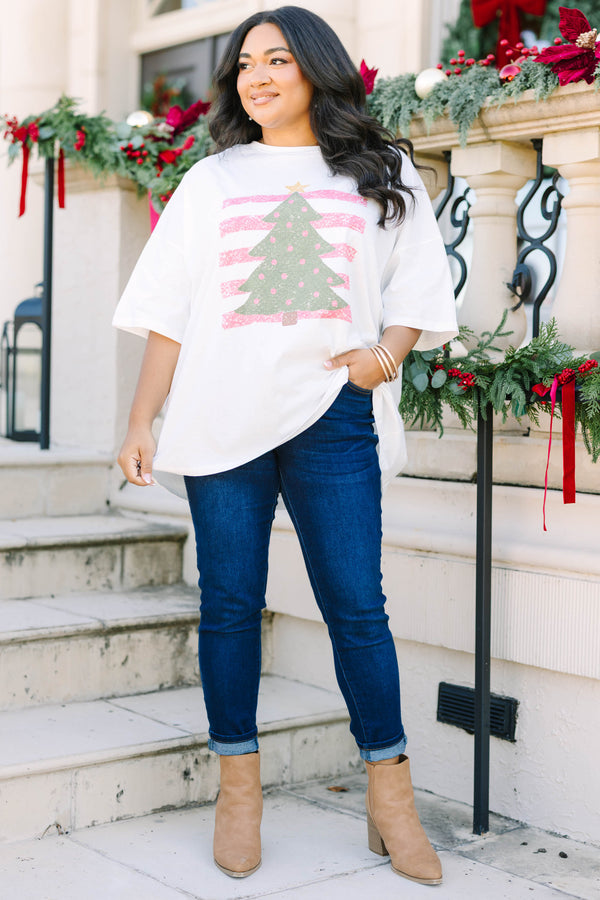 Plus Size white boyfriend tee with a green Christmas tree graphic and pink striped background.