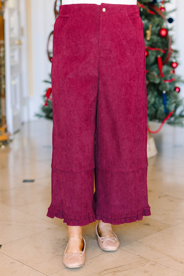 Plus Size burgundy corduroy wide-leg pants with a ruffled hem and side pockets.