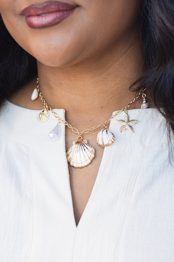 Chic Soul plus size clothing, gold necklace with various seashell charms hanging of the gold chain 
