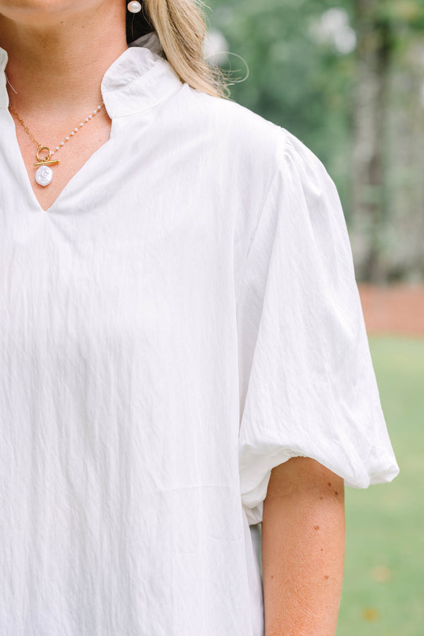 Plus Size ivory top with a ruffled v-neckline and short puff sleeves paired with blue jeans.